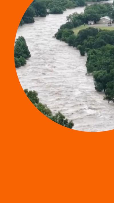 A river flooded in Texas, with trees on the banks.