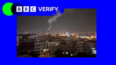 A skyline of Iran showing a plume of smoke after Israeli strikes