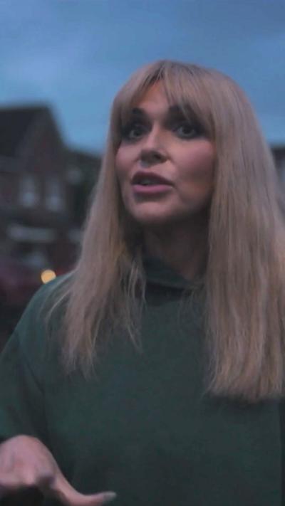 Woman with blonde hair and green jumper 
