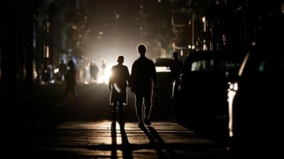People walking in a darkened street in Havana, Cuba
