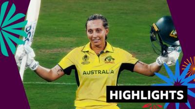 Ash Garnder raises her bat to celebrate reaching her century