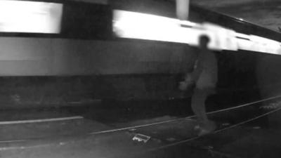 Teenager stands on tracks next to a speeding train.