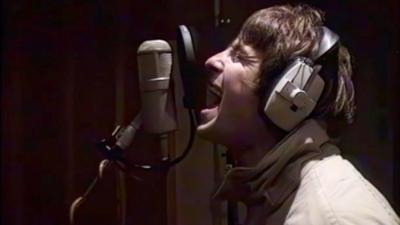 Liam Gallagher sings into a microphone in Rockfield Studios in 1995
