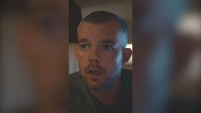 A man with a buzz cut looks shocked with his mouth agape