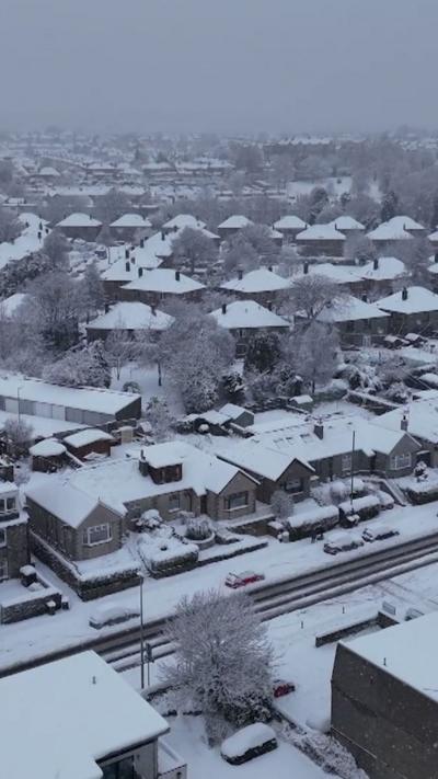 Aerial view of rows of houses and roads covered in snow