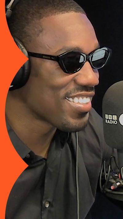 Giveon in dark glasses smiling