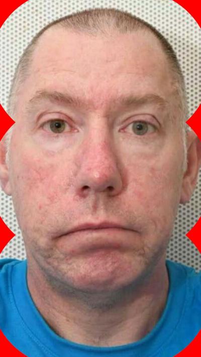 A man's mug shot in a blue t-shirt