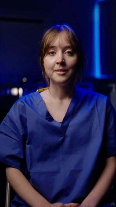 An actress playing a nurse, looking at the camera