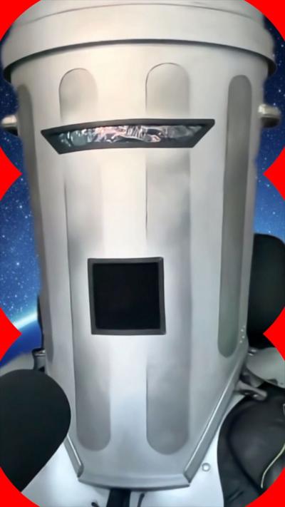 Count Binface wears a helmet that looks like a metal waste bin with grilles for his eyes and mouth, and speaks into a mic.