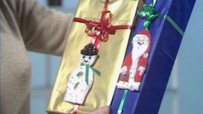 Two presents with a snowman and a Santa card on them