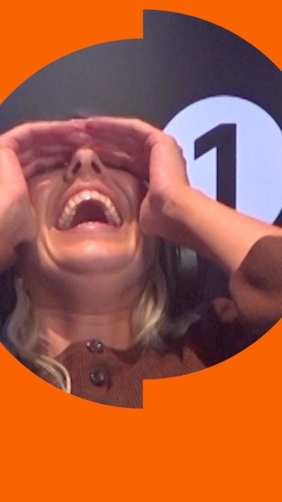 Mollie King leans back while laughing with her hands over her eyes