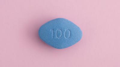 A blue pill with "100" printed on it