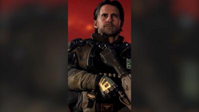 Call of Duty actor Milo Ventimiglia wearing a black jacket and holding a big gun, in character.