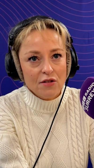 A woman wearing headphones and cream jumper