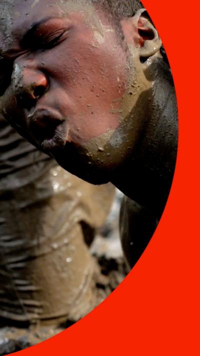 A man grimaces, she is covered in mud.