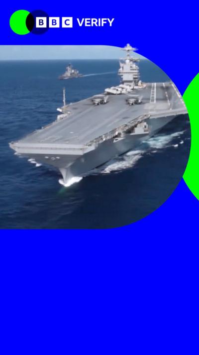 A US warship with jets parked on it imposed over the BBC Verify branding and colours. 
