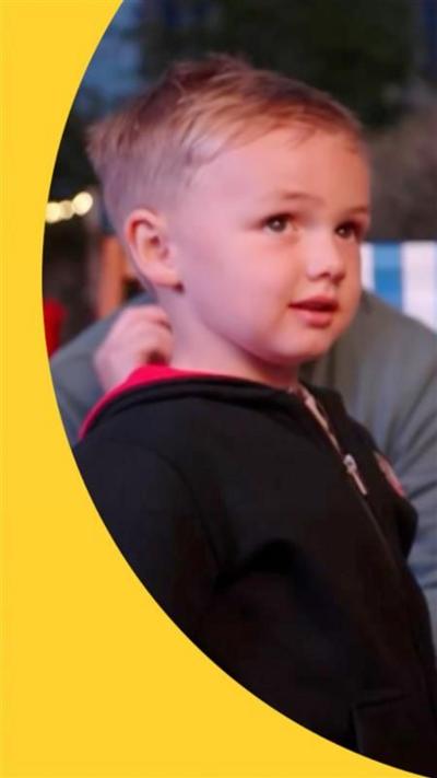 A boy with blond hair looks to the side
