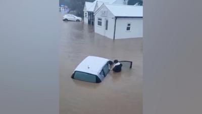 A still showing the moment the woman is rescued from the car