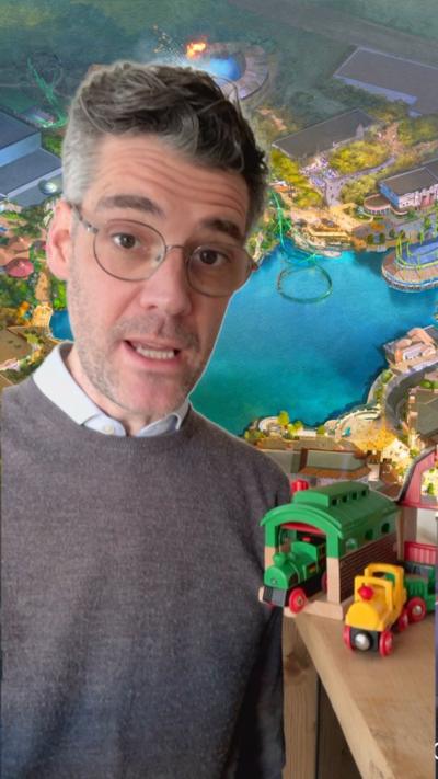 Reporter stands in front of Universal UK theme park image