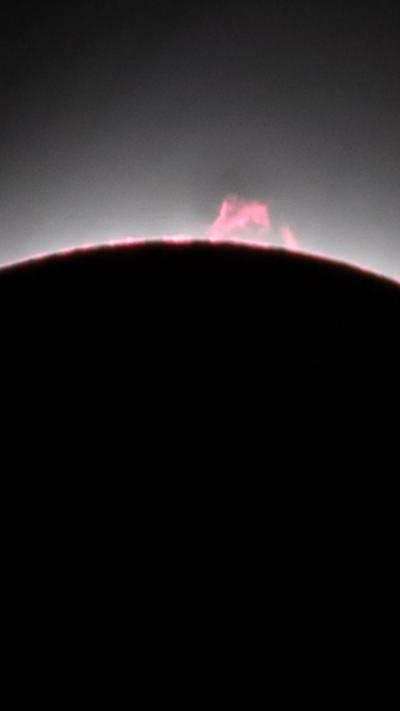 What looks like pink flames roll off the backed out Sun