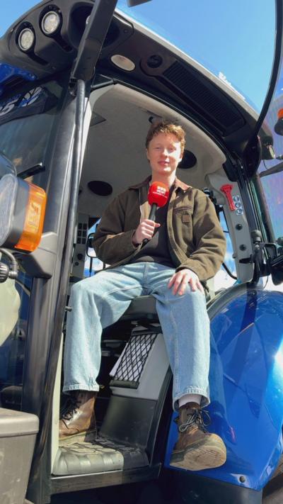 A man sitting in a tractor holding a microphone