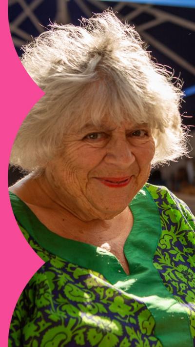 Miriam Margolyes, in a green top, smiles outside