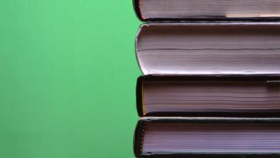 A pile of books on a green background.