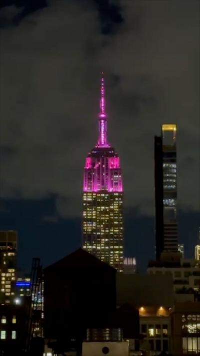 The Empire State building glows pink.