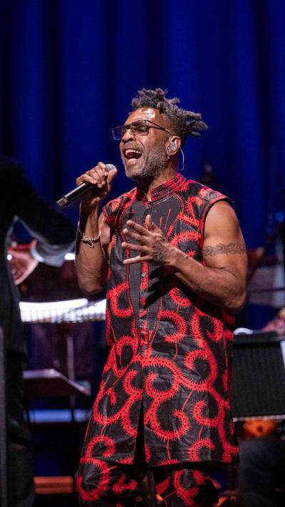 Male singer performing passionately on stage with microphone