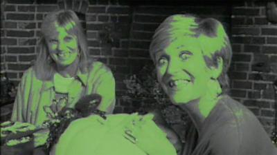 Linda McCartney and ý reporter make scary faces. There is a green filter on the image