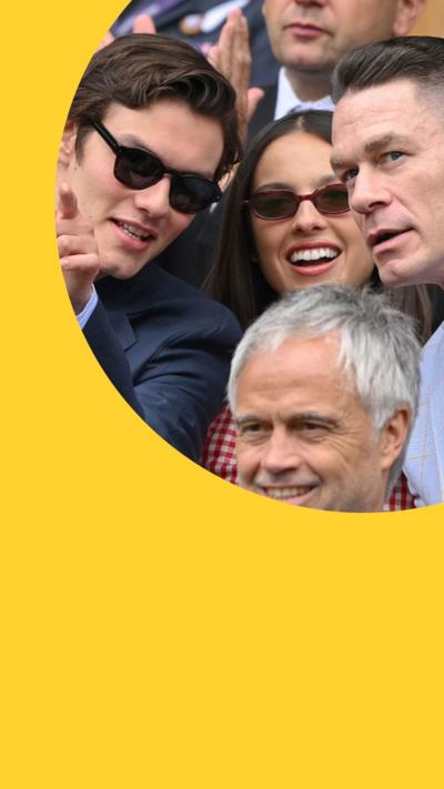 Louis Partridge, Olivia Rodrigo and John Cena looking into the distance in the stands at Wimbledon