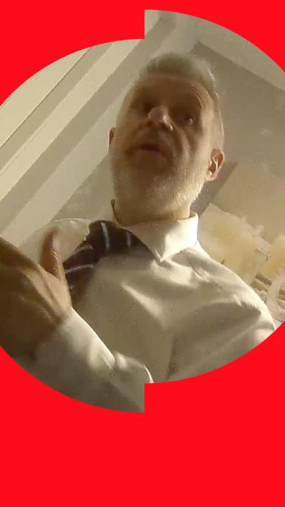 Low-angle image of a person wearing a white shirt and striped tie.