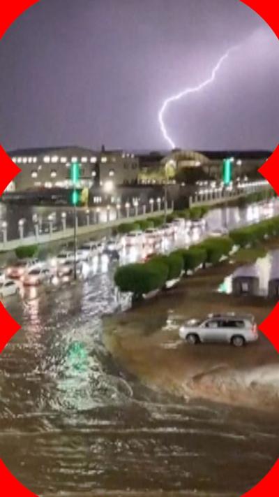 Cars on flooded road, lighting striking in the background