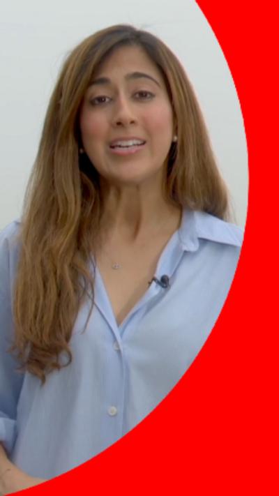 A woman with long brown hair wearing a light blue shirt.
