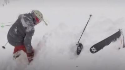 A rescuer is rescuing a skier that is under the snow. 