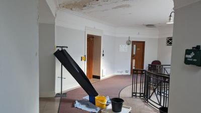 damaged ceiling at the museum with buckets underneath