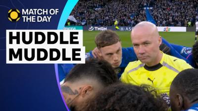 Referee Paul Tierney in the middle of the Chelsea huddle