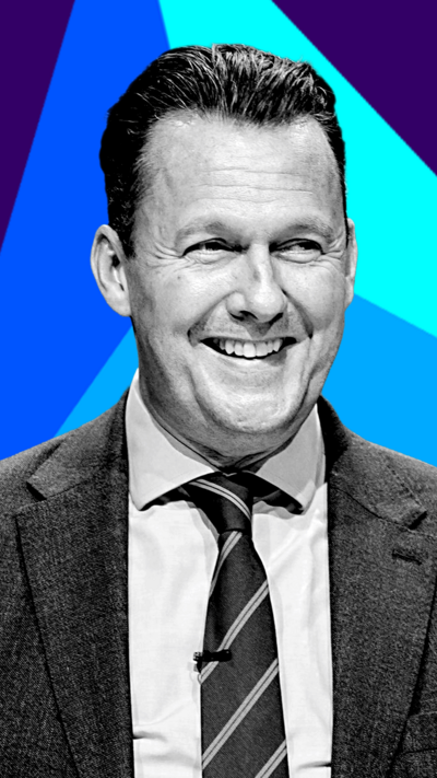 Scottish Conservative leader Russell Findlay smiles as he looks away from the camera. He is wearing a suit and tie.