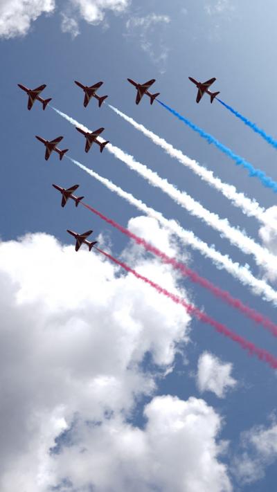 Red Arrow planes take a V formation with red, white and blue smoke trails