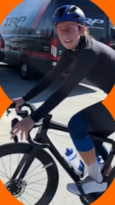 A woman on a bike talks to the camera