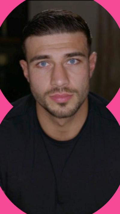 Tommy Fury looks at the camera. He wears a black tshirt and has short dark hair and blue eyes.