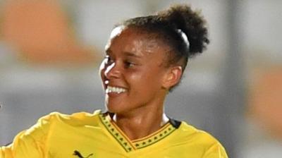 Chantelle Boye-Hlorkah in action for Ghana in a yellow jersey smiles during a match
