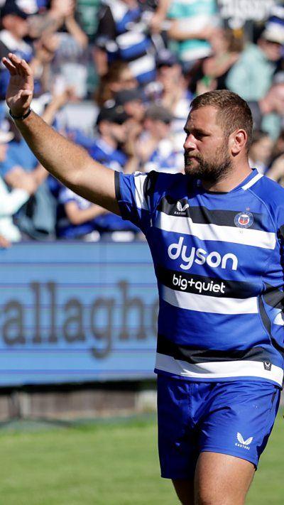 A male Bath rugby player in a blue and white kit