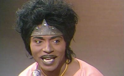 A close up of Little Richard speaking to the interviewer.