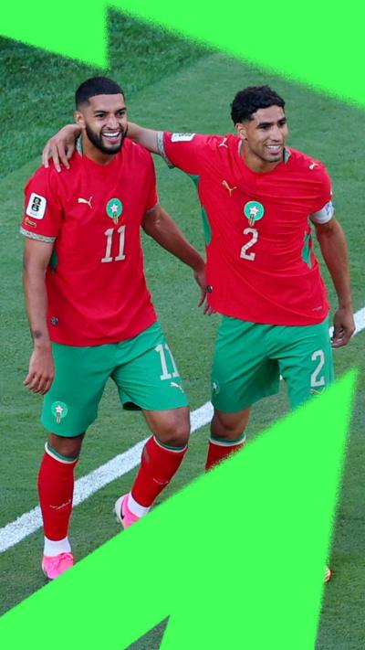 Morocco's Ismael Saibari and Achraf Hakimi smiling on the football pitch.