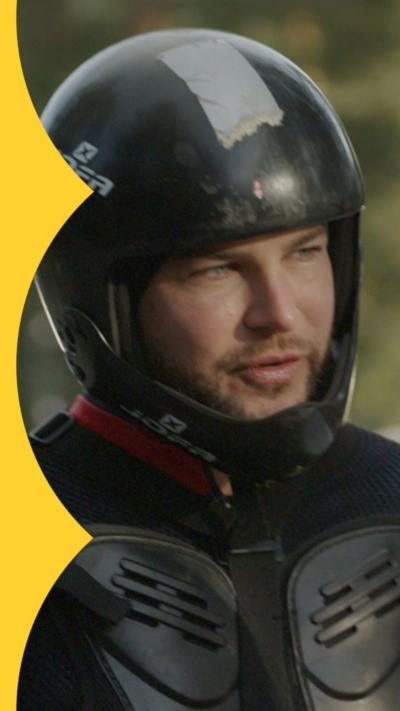 Chris Hughes wears black protective gear including a helmet 