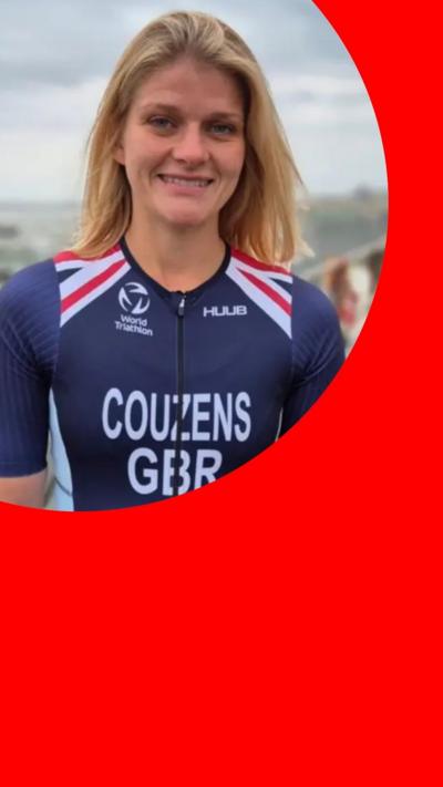 Georgia Couzens, in a blue Team GB bodysuit, stands on a beachfront. She is smiling and has long blonde hair
