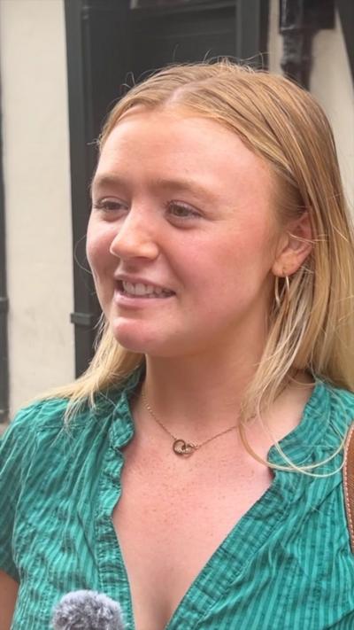 A young blonde woman in a green striped top