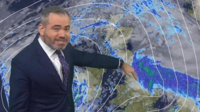 BBC weather presenter Ben Rich stands in front of a weather graphic