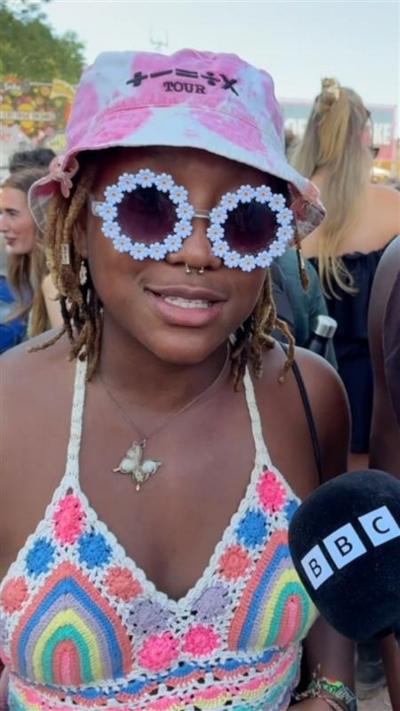 A girl in flowery sunglasses and a pink hat